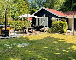 Exterior of Cottage in Ermelo, Veluwe, with hot tub and hammock in the garden.