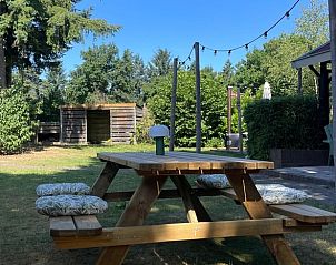 Wooden picnic table in the garden of Holiday home in Ermelo, Veluwe, ideal for outdoor dining.