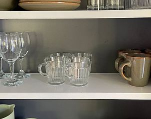 Open cabinet with glasses and mugs in Holiday cottage in Ermelo, Veluwe, practical and stylish.