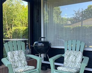 Terrace with barbecue and chairs in Holiday home in Ermelo, Veluwe, for cozy evenings.