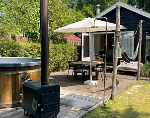 Outdoor terrace with hot tub and hammock at cottage in Ermelo, Veluwe, ideal for relaxing.