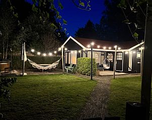 Cottage in Ermelo, Veluwe, attractively lit in the evening, surrounded by nature.