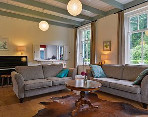 Gemtliches Wohnzimmer eines Ferienhauses in Ermelo, Veluwe, Gelderland, mit Holzboden und stimmungsvoller Beleuchtung.