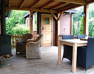 Veranda met houten meubels bij De Leuvenhorst/Haspel, Ermelo, Veluwe. Vakantiehuis met een gezellige buitenruimte.