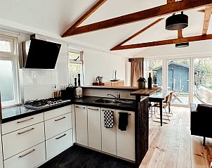Modern kitchen and bright living room in Cottage in Ermelo, vacation home on the Veluwe in Gelderland, overlooking the garden.