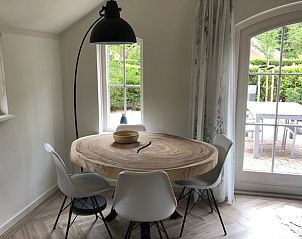 Dining area with wooden table in Holiday home in Ermelo, Veluwe, Gelderland with lots of light.