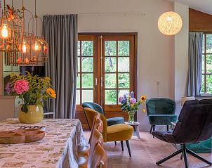 Cozy living room in Cottage in Ermelo, Veluwe, with colorful chairs and views of nature in Gelderland.