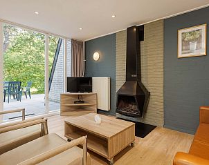 Gemtliches Wohnzimmer des freistehenden Hauses in Hoenderloo, Veluwe, mit moderner Einrichtung und Blick auf die grne Umgebung von Gelderland.