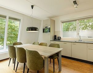 Eethoek in Bosvilla 6-7, Hoenderloo, Veluwe, met uitzicht op de groene omgeving.