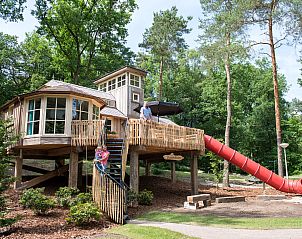 Gezellige woonkamer in Miggelenberg boomhut, met houtkachel en uitzicht op de Veluwe.