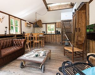 Rustieke binnenruimte van Miggelenberg boomhut in Hoenderloo, met houten interieur.