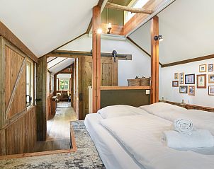 Gezellige slaapkamer in Miggelenberg boomhut, met houten details en moderne inrichting.
