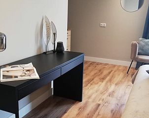 Stilvolles Interieur des Ferienhauses in Hoenderloo, Veluwe, mit Holzboden und moderner Einrichtung.