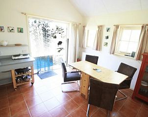 Lichte eetruimte in Vakantiehuis in Terwolde, Veluwe, Gelderland, met uitzicht op de tuin en moderne voorzieningen.