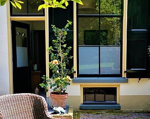 Zonnig terras van Huisje in Terwolde, vakantiehuis op de Veluwe, met gezellige zitplek en groene omgeving.