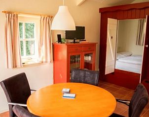 Eethoek en slaapkamer van Vakantiehuisje in Terwolde, Veluwe, Gelderland met landelijke sfeer.