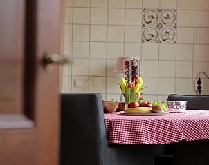 Eettafel met bloemen in Vakantiehuis in Terwolde, Veluwe, Gelderland, ideaal voor ontbijt.