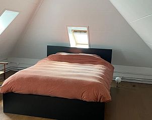 Knusse slaapkamer in Huisje in Terwolde, vakantiehuis op de Veluwe, met dakraam en rustieke sfeer in Gelderland.