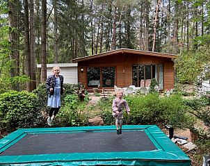Kinder spielen auf dem Trampolin im Ferienhaus in Garderen, Veluwe, umgeben von Wldern in Gelderland.