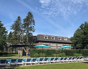 Zonnig zwembad met ligstoelen bij Vakantiehuisje in Garderen.