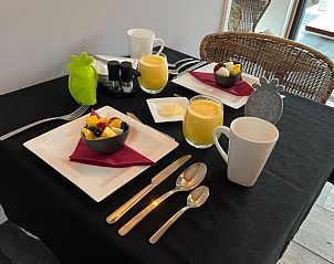 Breakfast table set for two in Holiday cottage in Garderen, Veluwe, with fresh juice and fruit.