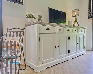 Witte kast in De Veluwse houtduif, Garderen, Veluwe met decoratieve lamp en boeken.