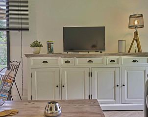 TV-meubel in De Veluwse houtduif, Garderen, Veluwe met flatscreen en decoratieve items.