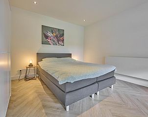 Ruime slaapkamer in De Veluwse houtduif, Garderen, Veluwe met kunst aan de muur.