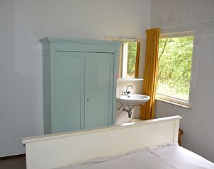 Slaapkamer met vintage kast in Vakantiehuis in Elspeet, omgeven door Veluwse natuur.