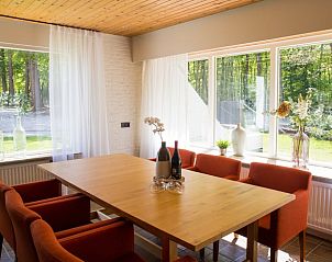 Gezellige eetruimte in Vakantiehuis in Elspeet, Veluwe, met uitzicht op de groene natuur van Gelderland.