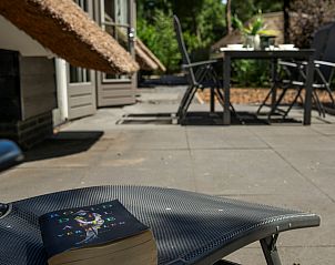 Relax with a book on the veranda of Holiday home Sprielderbosch 14 't Sprielderhof, Putten, Veluwe.
