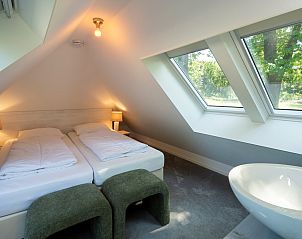 Dining area and living room in Holiday home Sprielderbosch 25 'Meneer de Uil', located in Putten, Veluwe.