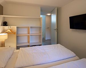 Bedroom with TV and storage in Holiday home Sprielderbosch 25 'Meneer de Uil' on the Veluwe, located in Putten.