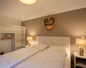 Bedroom with heart-shaped wall decoration in Holiday home Sprielderbosch 25 'Meneer de Uil' on the Veluwe, located in Putten.