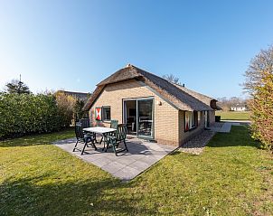Gelderse Hoevewoning 4 in Putten, Veluwe, een charmante bungalow met rieten dak en zonnig terras, omringd door groene natuur.