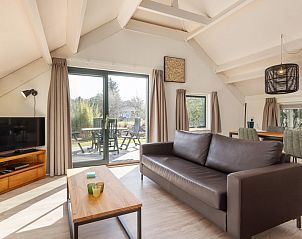 Gezellige woonkamer van Gelderse Hoevewoning 4 in Putten, Veluwe, met uitzicht op terras en groene omgeving.