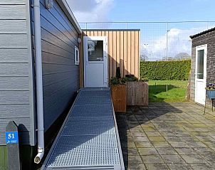 Schlafzimmer im DG1546-Ferienhaus Putten Veluwe mit bequemen Betten und Kunst an der Wand.