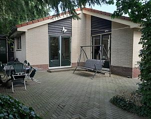 Terras van El Granero vakantiehuis in Putten, Veluwe met comfortabele zithoek en schommelbank.