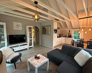 Gezellige woonkamer in Vakantiehuisje in Putten, Veluwe, met moderne inrichting en sfeervolle verlichting, ideaal voor ontspanning.