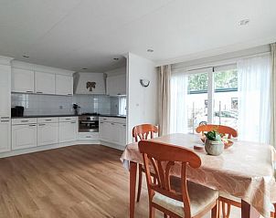 Cozy dining room and kitchen of Huisje in Putten, vacation home on the Veluwe in Gelderland, with lots of natural light and modern amenities.