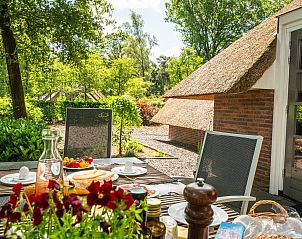 Cozy breakfast on the terrace of Vakantiewoning Sprielderbosch 38 De Houten Uil, in the middle of the Veluwe forests.