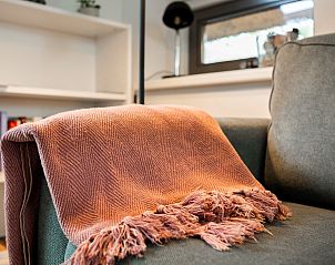 Warme Decke auf dem Sofa im Ferienhaus Sprielderbosch 27 De Uitlaat in Putten, Veluwe, ein perfekter Ort zum Ausruhen.