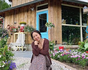 Visitor enjoys the floral display at Cottage in Voorthuizen, vacation home in Veluwe, Gelderland.