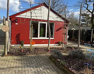 Exterior facade of Holiday Home in Voorthuizen, Veluwe, with blooming flowers in the front yard.