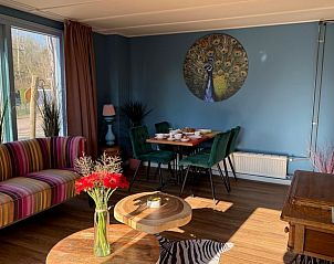 Dining room in Holiday Home in Voorthuizen, Veluwe, with colorful decorations and comfortable chairs.