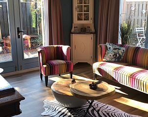 Bright living room in Holiday Home in Voorthuizen, Veluwe, with large windows and cozy furnishings.
