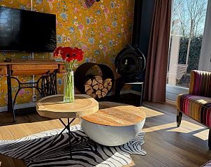 Cozy sitting area in Holiday Home in Voorthuizen, Veluwe, with modern art and flowers.