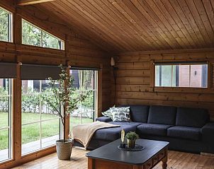 Gezellige woonkamer van Vakantiehuis de Blokhut in Voorthuizen, Veluwe. Houten interieur met uitzicht op de groene omgeving.