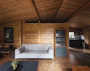 Gezellige binnenruimte van Vakantiehuis de Blokhut in Voorthuizen, Veluwe. Houten interieur met comfortabele zithoek en moderne keuken.