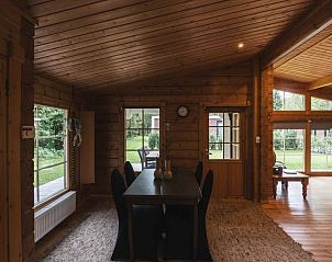Gezellige binnenruimte van Vakantiehuis de Blokhut in Voorthuizen, Veluwe. Houten interieur met uitzicht op groene tuin.